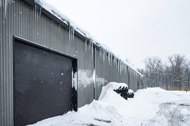 ghiaccioli congelati appesi al bordo del tetto del magazzino industriale - icicle hanging snow moving down foto e immagini stock