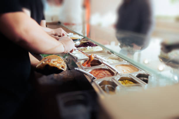 istock Cook putting tomatoes sauce in a Flat Bread Sandwich 1379796799