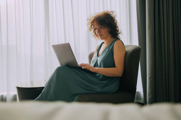istock Working from Home: Caucasian Businesswoman Writing a Report on her Laptop Computer 1379811996