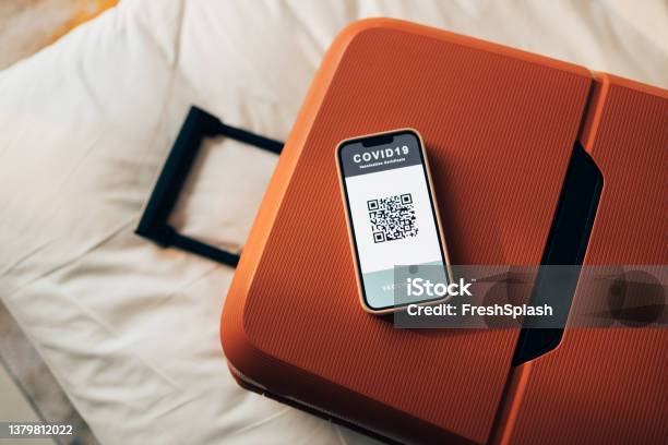 Getting Ready For Vacation A Red Suitcase With A Smartphone Screen Showing A Covid Vaccination Qr Code Stock Photo - Download Image Now