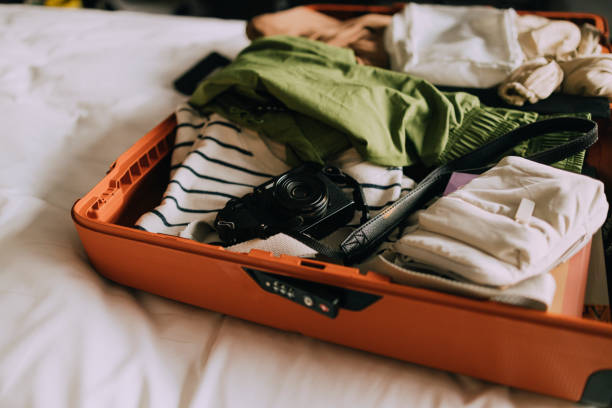 istock Packing the Essentials for Vacation: Open Suitcase Full of Clothes on a Bed with White Sheets 1379812043