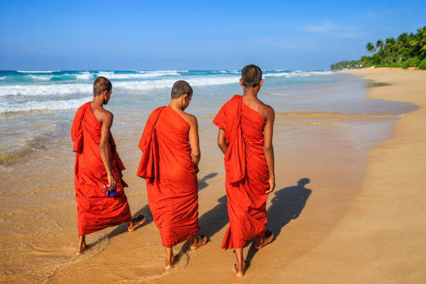 istock Sri Lankan young buddhist monks walking on the beach, Ceylon 1379822941
