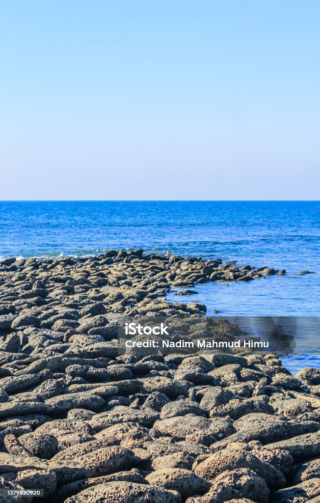 Giant's Causeway in St. Martin's Island, Bangladesh. Magical sunrise, clouds, and waves hitting the coast. Giant's Causeway looks like a jetty. Copy space. Bangladesh Stock Photo