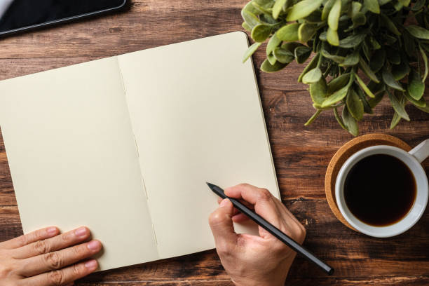 istock top view hand writing on notebook and coffee cup on wood office desk 1379831805