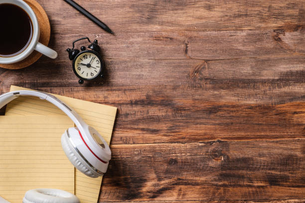 istock top view working desk with headphone and notebook, coffee cup on wooden table background 1379831858