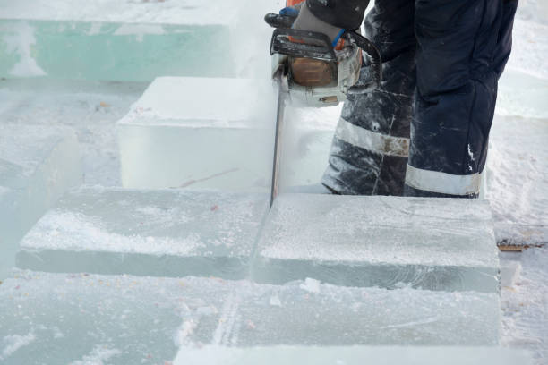 istock Worker cuts a lump of ice with a chainsaw 1379868800