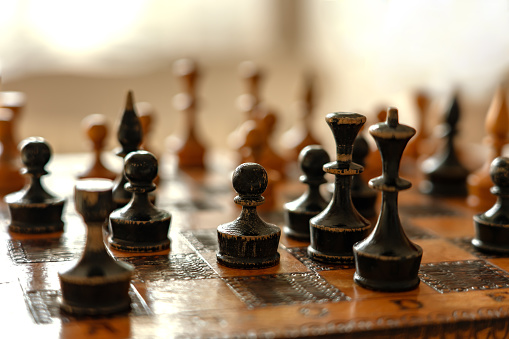 pawn with other figures on the vintage old chess board .