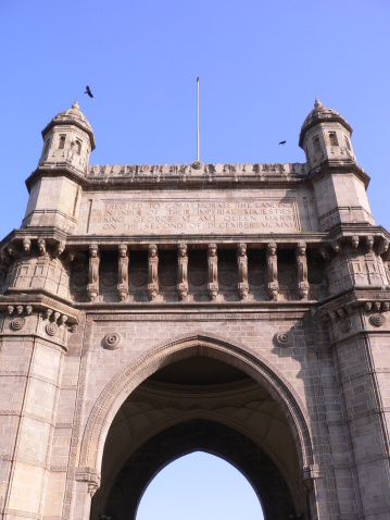 View of the gateway to India in Bombay with birds flying above.