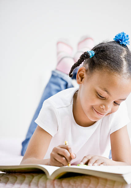 istock Happy girl coloring in book 137988789