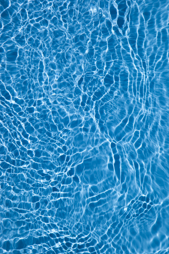 Ripple Blue Water Surface In Swimming Pool With Reflection Of Natural Sun Light