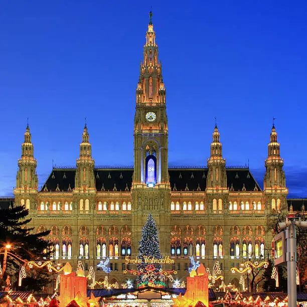 The New Town Hall (Neues Rathaus) of Vienna, Austria beautifully illuminated during Christmas time. In the square and park in front of the building one of the most famous Christmas Markets in the world is set as customary each year. HDR image with tone mapping during twilight.