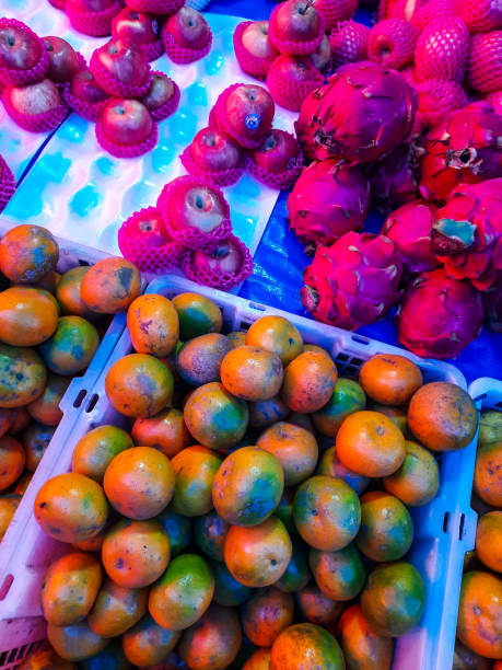 Fruit display case in the traditional market, orange, dragon fruit and apple