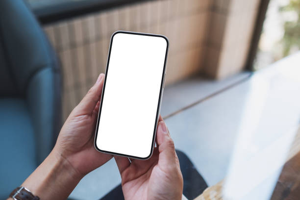 istock Mockup image of a woman holding and using mobile phone with blank desktop screen 1379937181