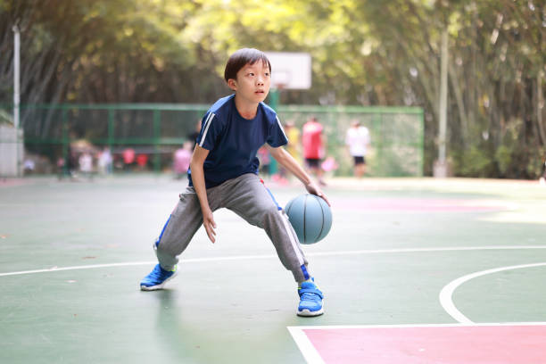 young boy playing basketbal - child basketball sport education imagens e fotografias de stock