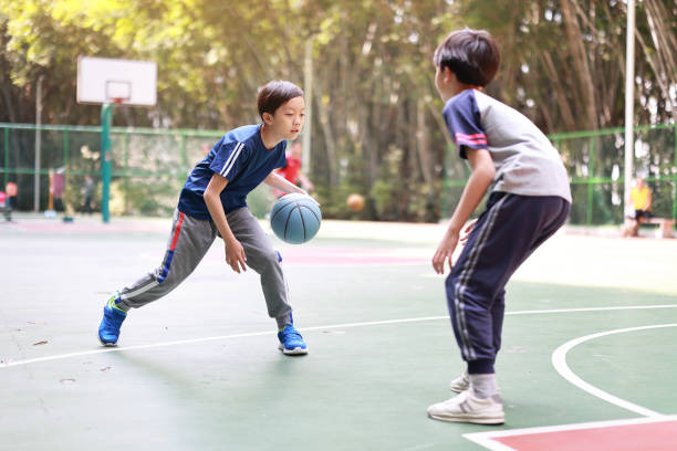 zwei jungen basketball spielen im freien - basketball teenager nature outdoors stock-fotos und bilder