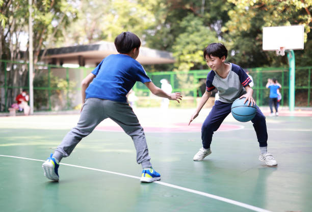 istock Two boys playing basketball outside 1379939790