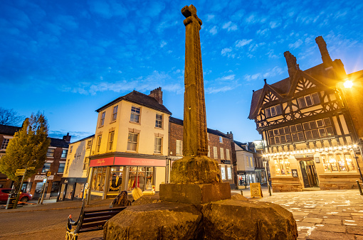 Market Cross on Market Place of Leek in Staffordshire, England. This dates from about the early 15th century and was listed in 1951 and is a scheduled ancient monument. In the background is the Butter Market and other notable buildings.