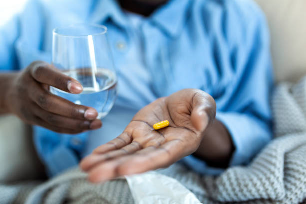 hombre negro sostiene pastillas y frasco en sus manos. concepto de atención médica y medicina, el paciente toma dosis diarias de medicamentos recetados, se siente enfermo, antibióticos, analgésicos o antidepresivos. cerrar - narcotic medicine pill insomnia fotografías e imágenes de stock