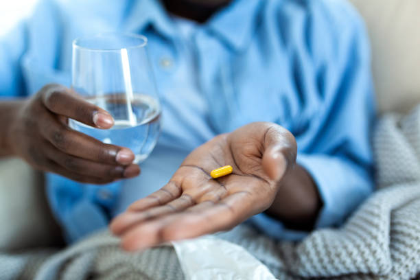 black man hold pills and jar in his hands. concept of healthcare and medicine, patient take daily dose of prescribed medicament, feel sick, antibiotics, painkillers or antidepressants. close up - narcotic medicine pill insomnia imagens e fotografias de stock