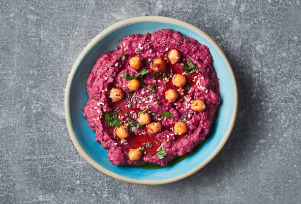 Beetroot vegan red hummus garnished with chickpeas olive oil and sesame seeds. Vegan diet super food.
