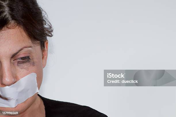 Battered Woman With Tape Over Mouth On An Offwhite Wall Stock Photo - Download Image Now