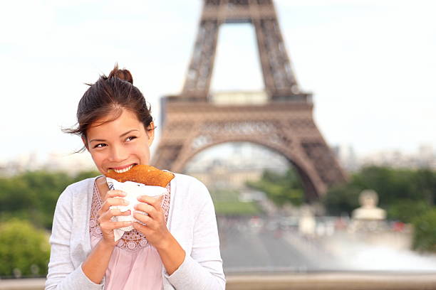 Paris woman by Eiffel Tower Paris woman eating pancake in front of Eiffel Tower, Paris, France during europe travel. More Paris images: crêpe pancake photos stock pictures, royalty-free photos & images