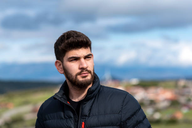 serious young bearded man looking away