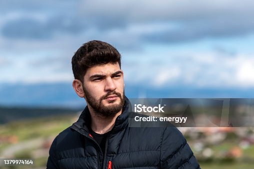 istock serious young bearded man looking away 1379974164