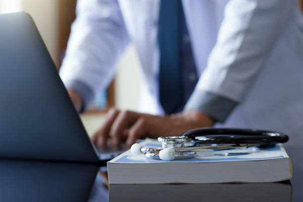 istock Male doctor hands typing on laptop computer 1379978460