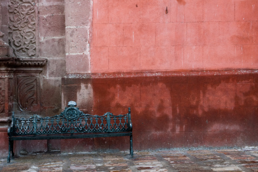 An old metal bech against coloful wall in San Miguel de Allende, Mexico.