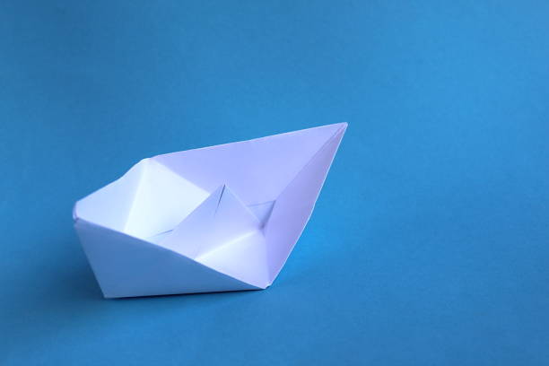 istock White paper boat lying on its side on a blue background 1379988328