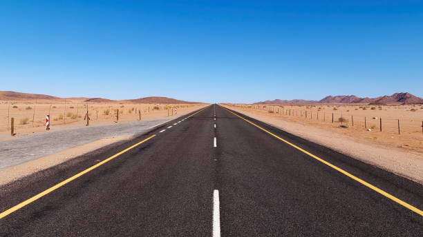 vista ad angolo basso della strada nella repubblica del sud africa alla namibia - arid climate asphalt barren blue foto e immagini stock