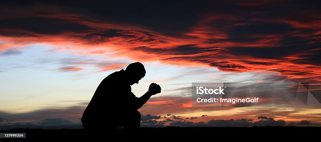 Silhouette di medio invecchiato uomo di Pregare - Foto stock royalty-free di Pregare