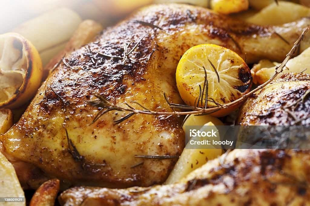 roast chicken closeup of roast chicken and oven potatoes Roast Chicken Stock Photo