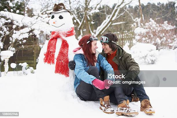 Teenage Para W Zimie Krajobraz Obok Bałwan Śniegowy - zdjęcia stockowe i więcej obrazów Bałwan śniegowy