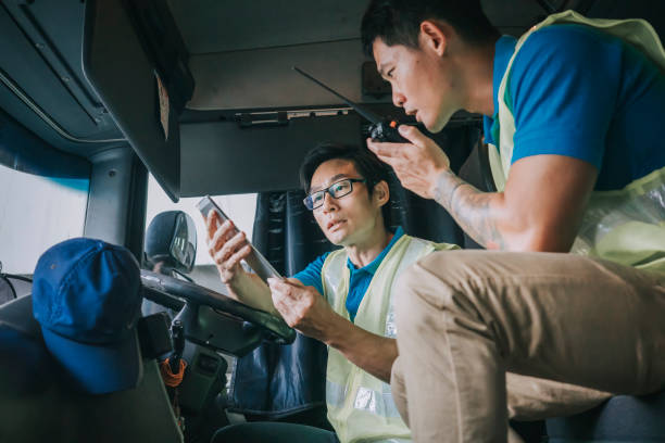 asiatisch-chinesische sattelschlepperfahrer kommunizieren mit fabriklagerarbeiter auf der lieferladeliste - computer manual worker truck driver truck stock-fotos und bilder