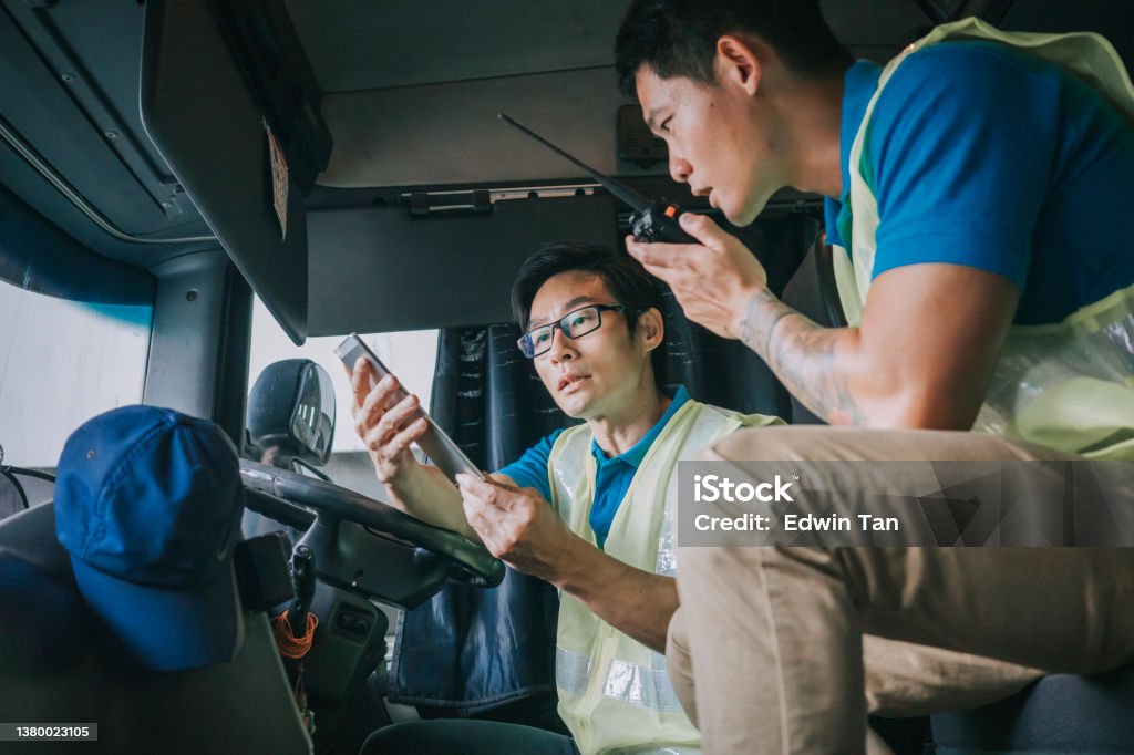 Asian Chinese semi truck driver communicate with factory warehouse worker on delivery loading list Truck Driver Stock Photo