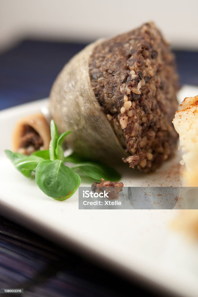 Cooked half haggis Apetising half haggis cooked presented  on a plate with a piece of lamb's lettuce Haggis Stock Photo