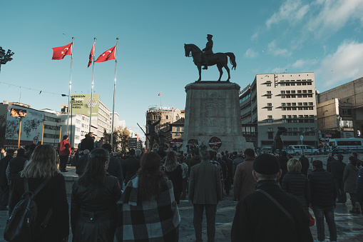 Ankara, Turkey - November 10, 2021: Victory Monument Ankara and people standing in homage on 10 November because the day is Ataturk's death anniversary.