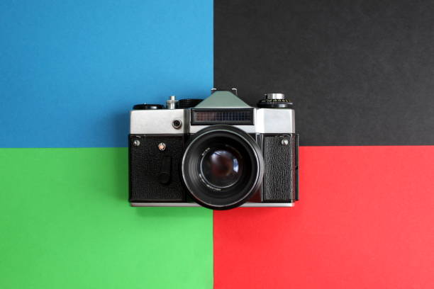 istock Retro camera. An old film camera lies on four different color backgrounds 1380064792