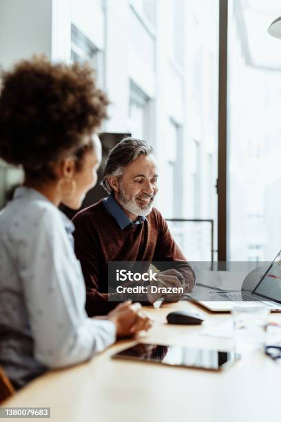 Smiling Financial Advisor And Business Person Talking To Mixed Race Female Colleague In Office Stock Photo - Download Image Now