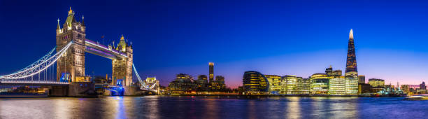 London Tower Bridge The Shard illuminated dusk over Thames panorama The iconic span of Tower Bridge spotlit at night overlooking the River Thames and The Shard in the heart of London, UK. gla building stock pictures, royalty-free photos & images