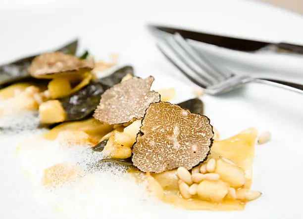 Photo of Black truffle ravioli with a fork