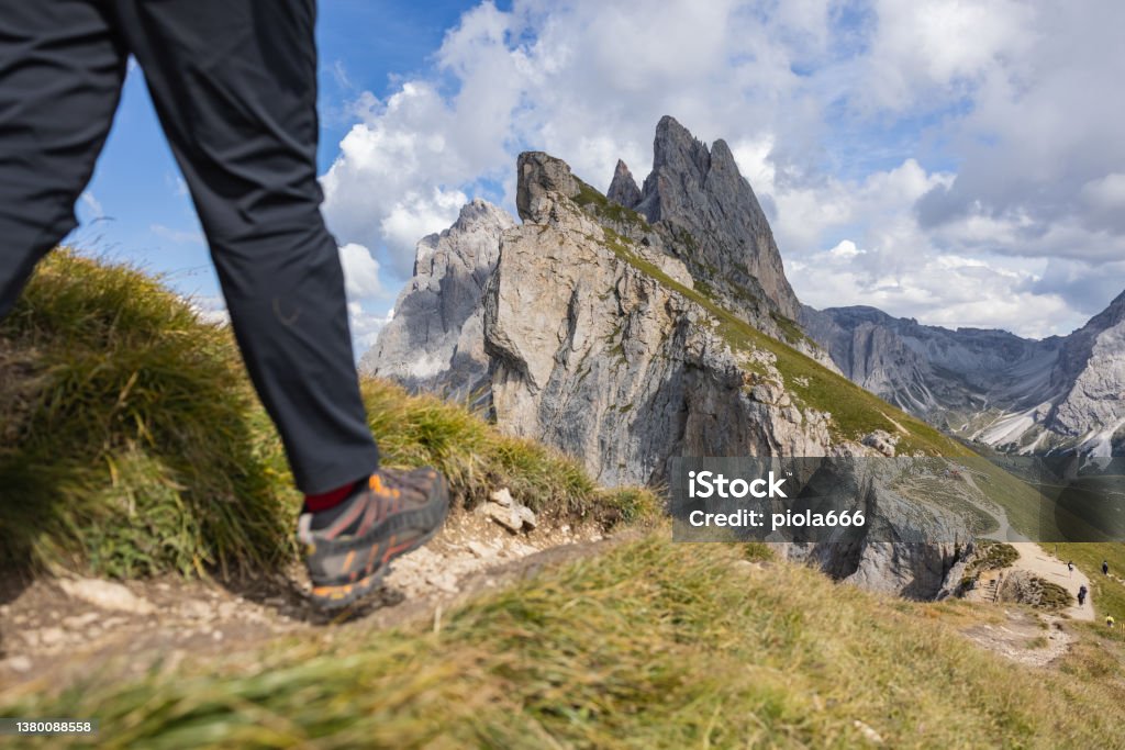 Woman hiking on the Seceda iconic outdoors landscape on the Dolomites Outdoors iconic landscape on the Dolomites: the Seceda famous landmark. A woman hiking alone in the majestic landscape 30-34 Years Stock Photo