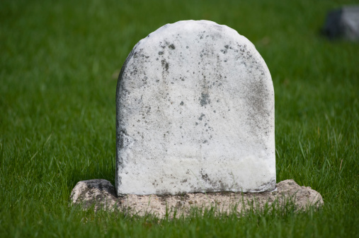 An old marble tombstone that has been aged by weather and time..