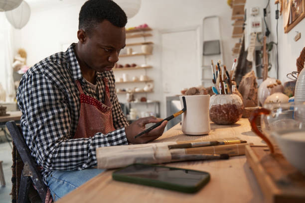 istock Concentrated young ceramic artist painting unglazed pottery 1380115413