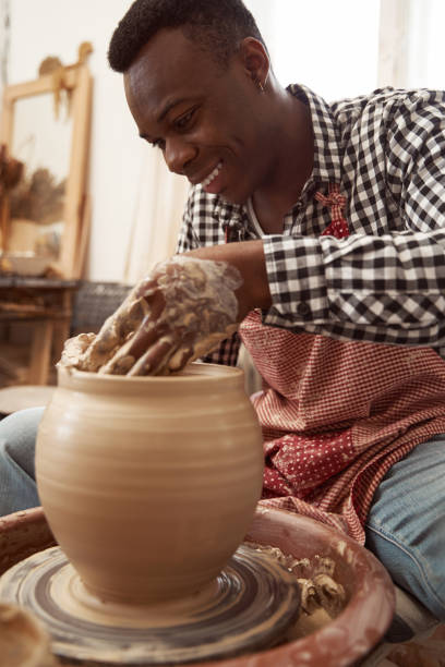 istock Joyous concentrated young ceramist throwing clay jar 1380115998