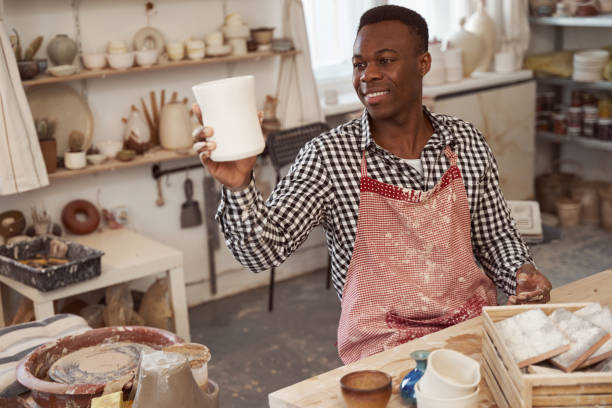 istock Pleased craftsman admiring his unglazed earthenware cup 1380116028