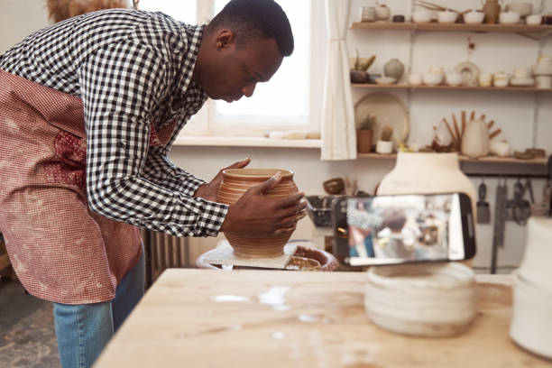 istock Focused male potter preparing pottery for drying 1380116029