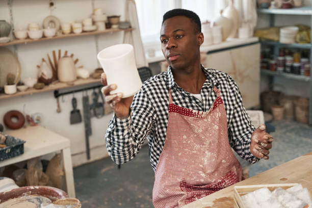 istock Focused young male potter examining unglazed pottery 1380116034